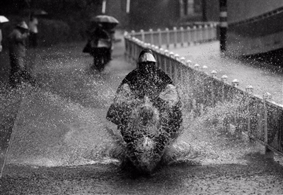 6月24日，杭州环城东路，一段近50米的道路积水严重，骑车人经过时溅起大片水花。