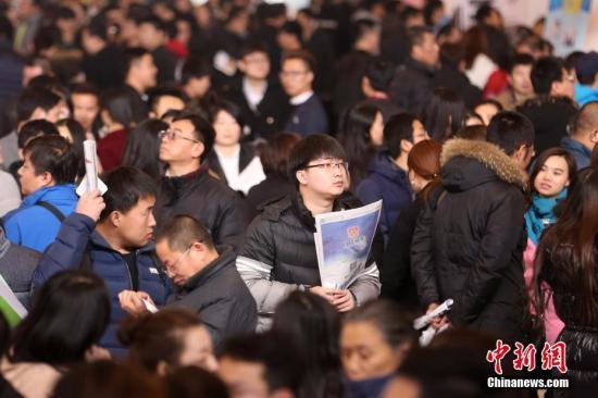 资料图 2月11日，北京国际会展中心举行春季人才招聘会，求职者在招聘会寻找合适的就业岗位。中新社记者 韩海丹 摄