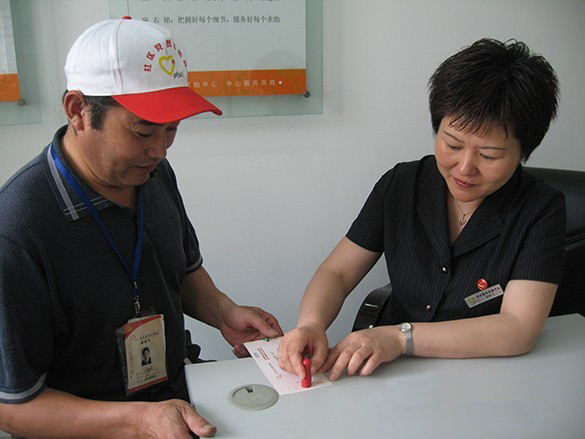 骆叶青（右）在为党员志愿者盖积分章。.jpg