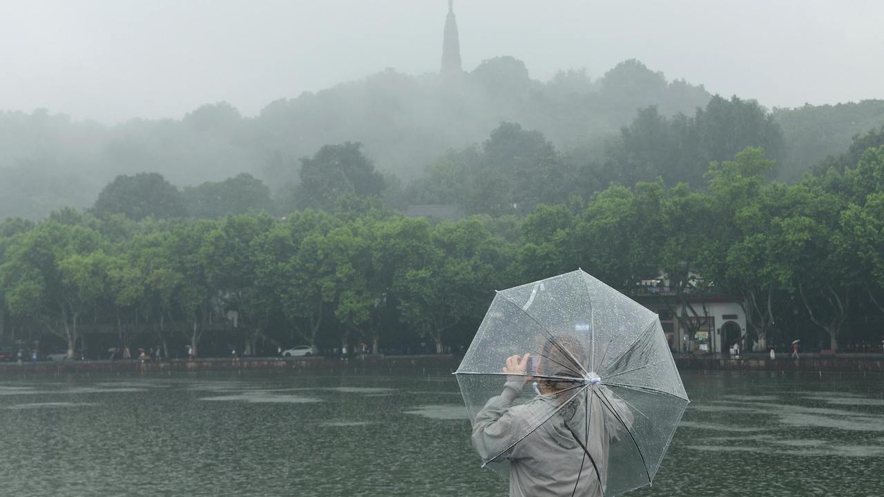 雨中西湖吸引游客驻足欣赏